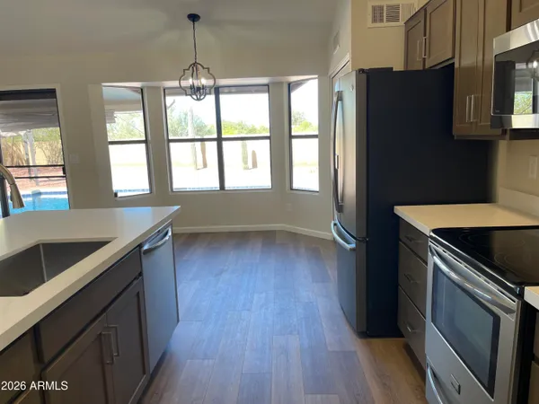 a kitchen with a wooden floor and a stove top oven