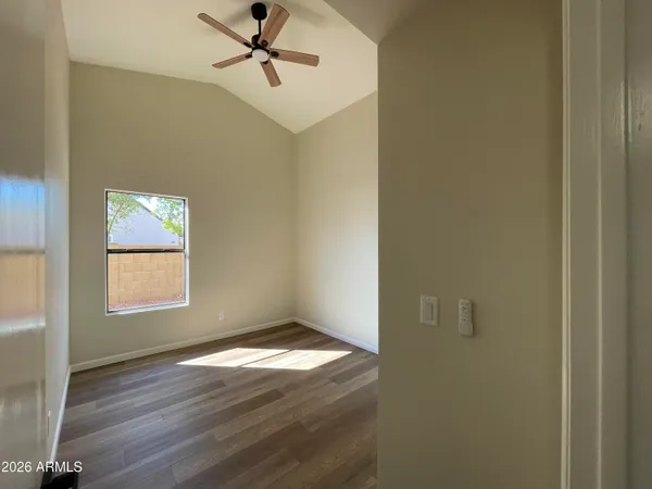 an empty room with windows and fan