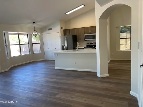 a view of kitchen with kitchen island wooden floors and stainless steel appliances