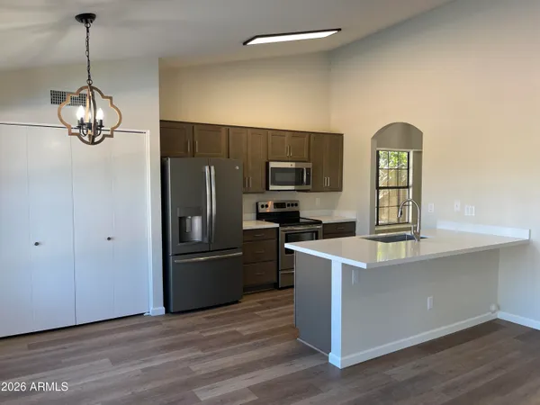 a kitchen with stainless steel appliances granite countertop a refrigerator a stove microwave and a sink