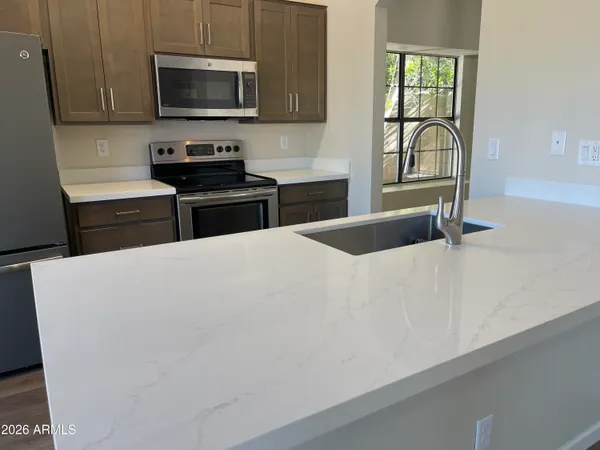 a kitchen with stainless steel appliances a microwave a sink and cabinets