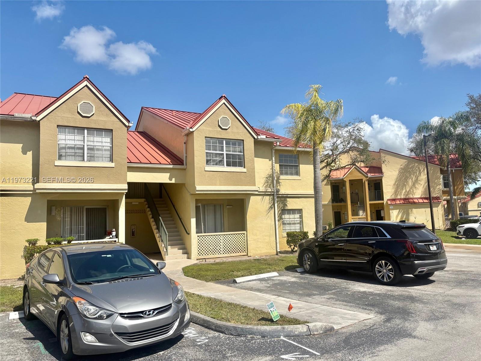18324 Northwest 68th Avenue, Unit H Hialeah, FL 33015 - Photo 2 of 9 a view of multiple house with cars park