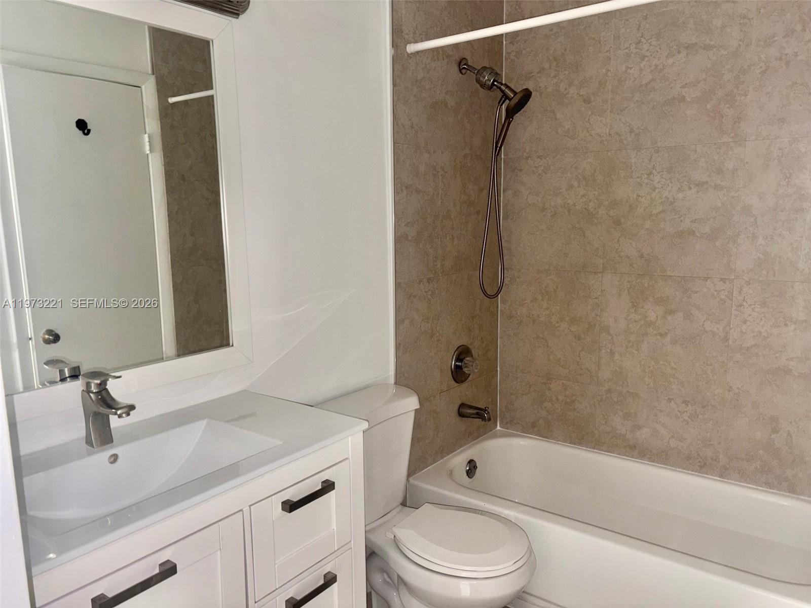 18324 Northwest 68th Avenue, Unit H Hialeah, FL 33015 - Photo 6 of 9 a bathroom with a granite countertop bathtub shower sink vanity and toilet