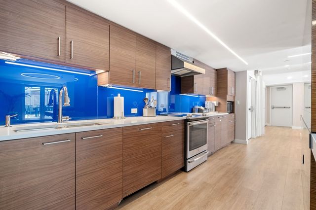 a kitchen with stainless steel appliances granite countertop a sink and wooden cabinets