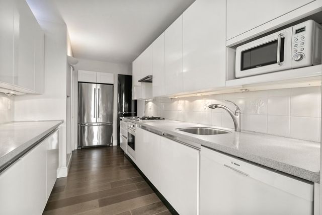 a kitchen with stainless steel appliances granite countertop a sink and a microwave