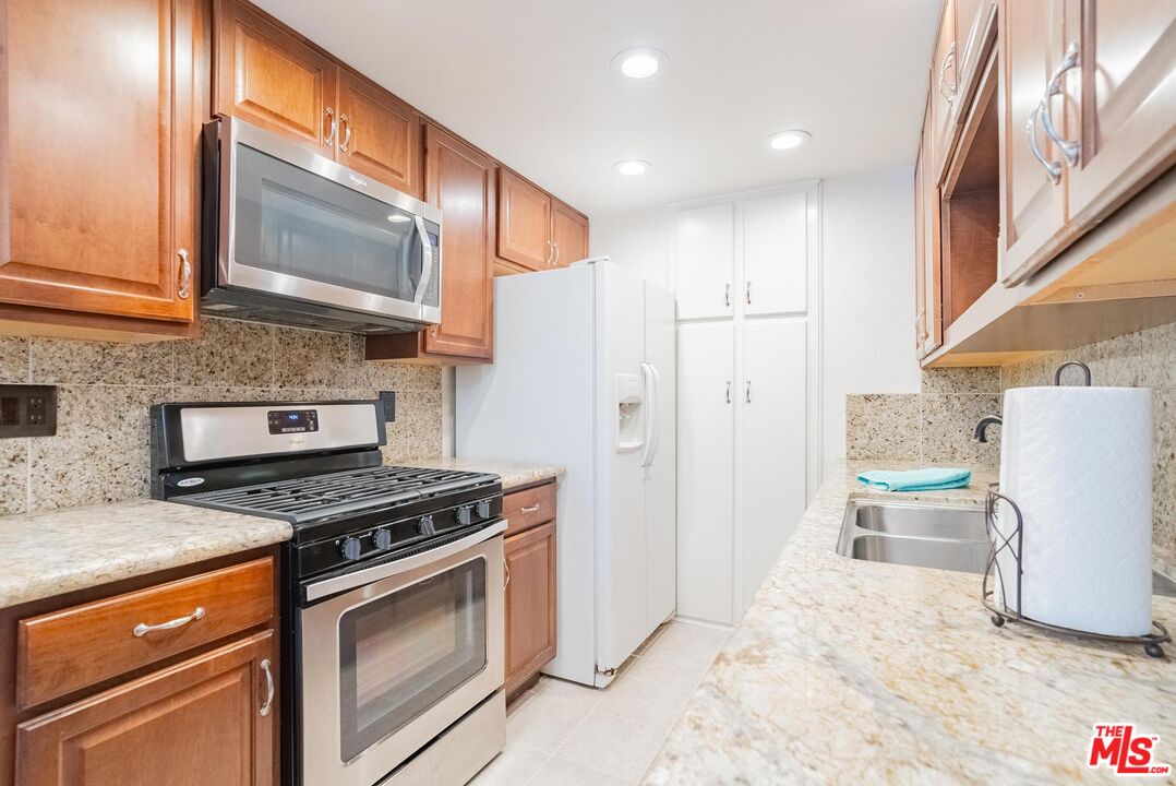 2567 Grambling Lane Riverside, CA 92507 - Photo 13 of 38 a kitchen with a refrigerator a stove top oven and a sink
