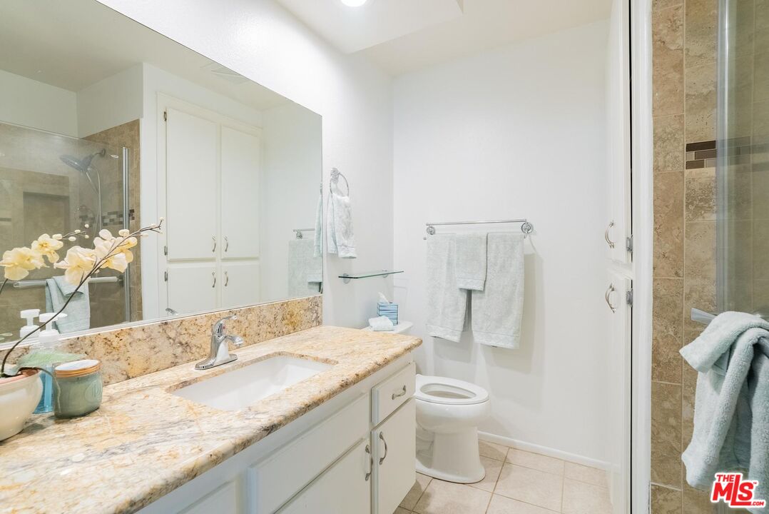 2567 Grambling Lane Riverside, CA 92507 - Photo 23 of 38 a bathroom with a granite countertop sink a toilet and shower