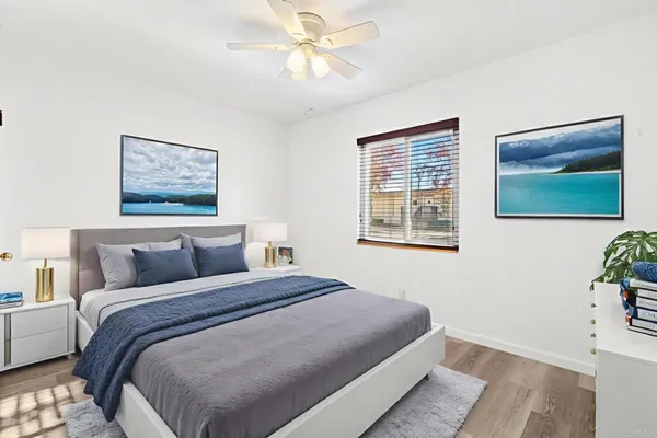 a bedroom with a bed and a painting on the wall