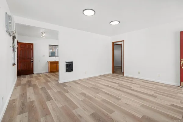 a view of empty room with a fireplace and wooden floor