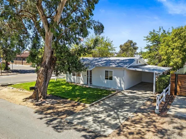 a view of a house with backyard and trees