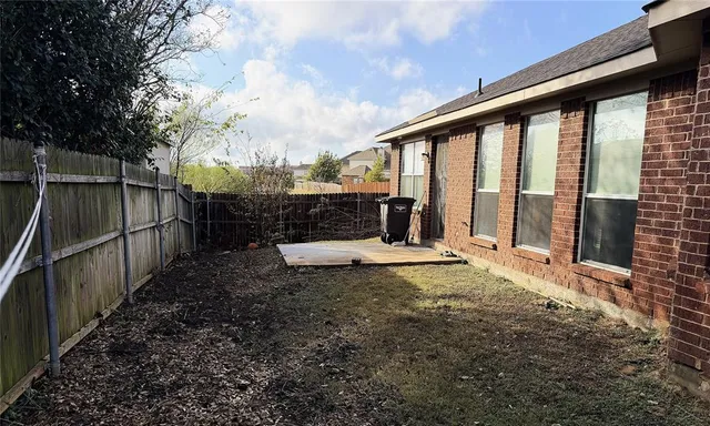 a view of a chair and table in the backyard