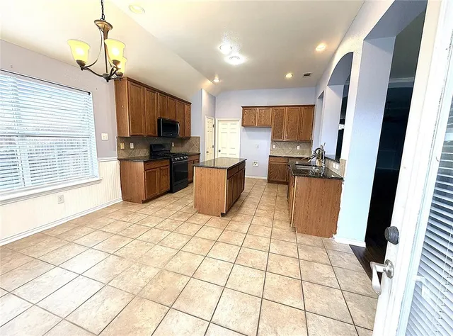 a living room with stainless steel appliances furniture a flat screen tv and a window