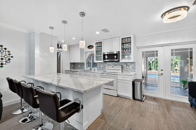 a kitchen with kitchen island granite countertop a sink cabinets and wooden floor