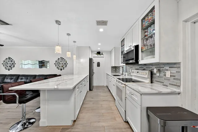a large kitchen with stainless steel appliances kitchen island granite countertop a sink and cabinets