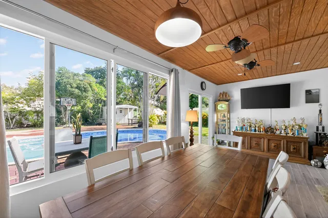 a living room with furniture large windows and flat screen tv