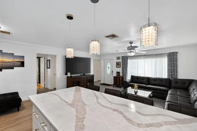 a living room with furniture a large window and a chandelier