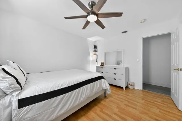 a bedroom with a large bed and a ceiling fan