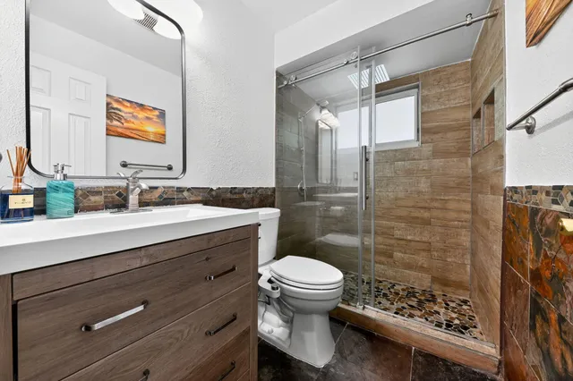 a bathroom with a sink a toilet and shower