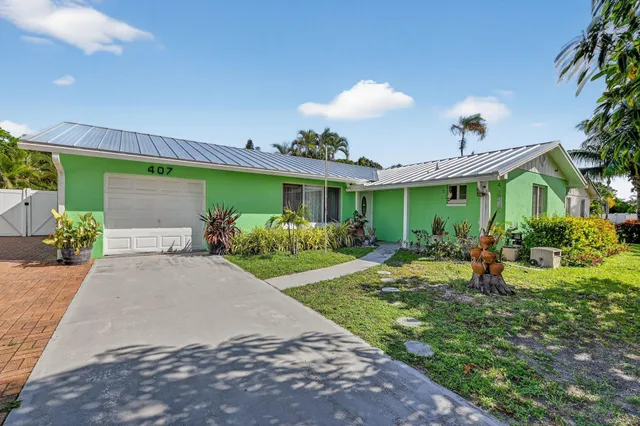 a front view of a house with a yard and a garden