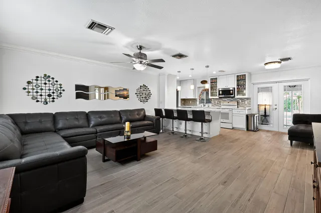 a living room with furniture and view of kitchen