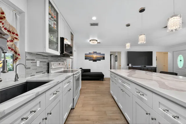 a large kitchen with a large counter top a sink and a stove