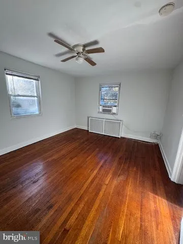 a view of room with wooden floor and ceiling fan
