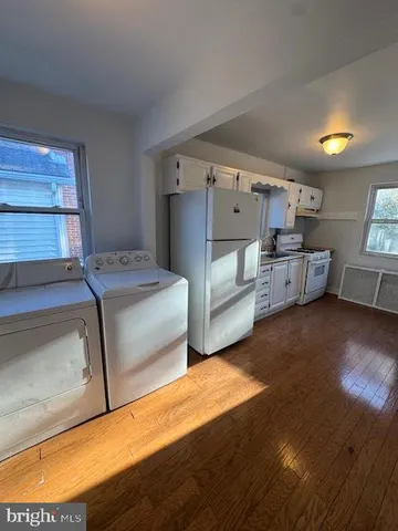 a spacious bedroom with a bed and wooden floor