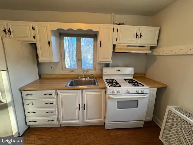 a kitchen with white cabinets and white appliances