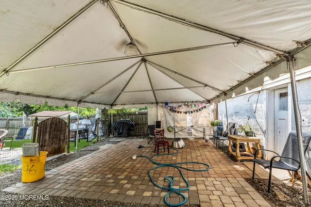 a view of patio with chairs and table under an umbrella
