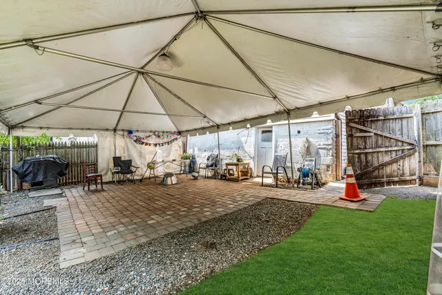 a view of a backyard with table and chairs under an umbrella