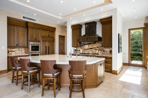 a kitchen with kitchen island granite countertop a sink and a large window