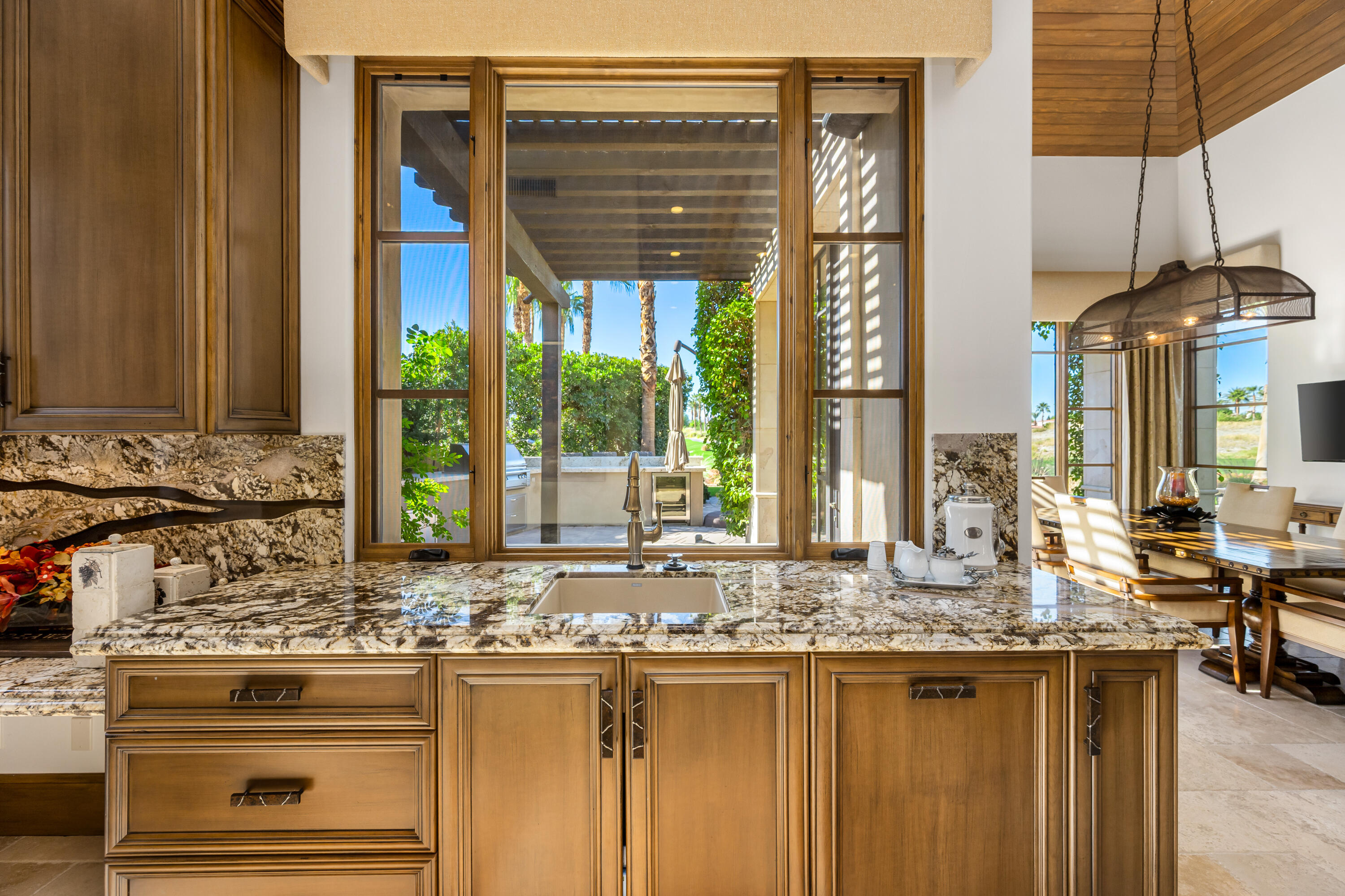 52711 Via Dona La Quinta, CA 92253 - Photo 18 of 61 a kitchen with kitchen island granite countertop a sink and a large window