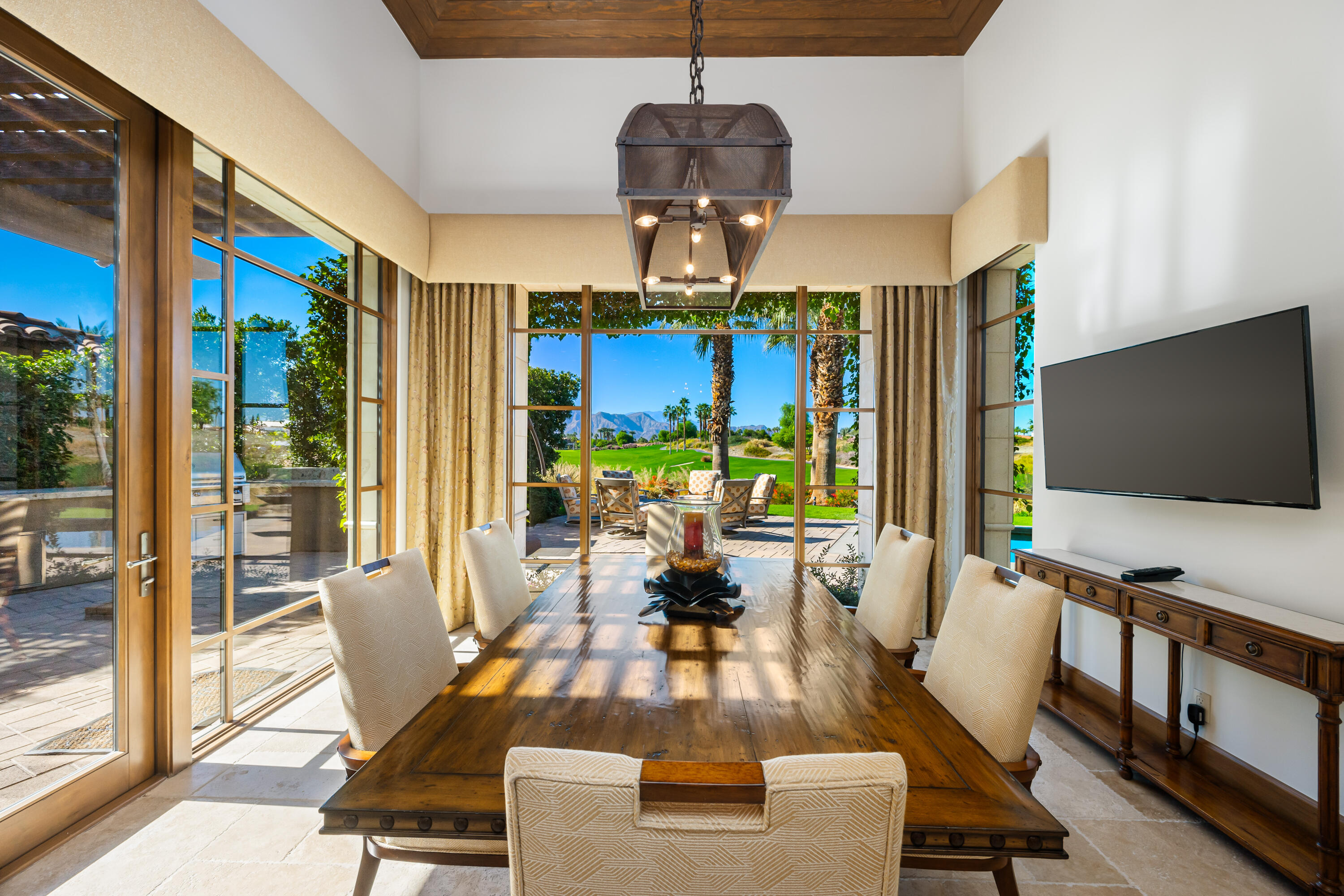 52711 Via Dona La Quinta, CA 92253 - Photo 21 of 61 a living room with patio fireplace furniture and a flat screen tv