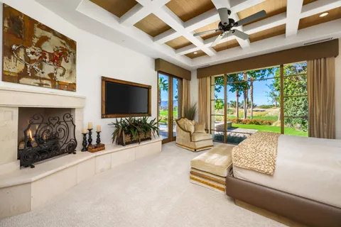 a spacious bedroom with a large bed and a chandelier