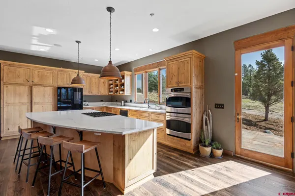 a kitchen with a stove a sink a refrigerator and a chandelier