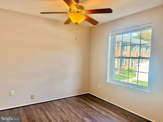 an empty room with a window and a fan