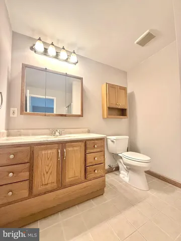 a bathroom with a toilet a sink and mirror
