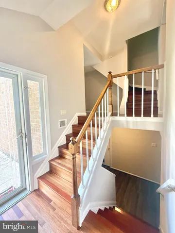 a view of staircase with lots of frames on wall and a window