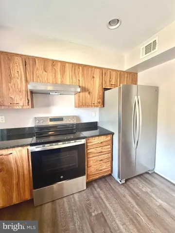a kitchen with stainless steel appliances granite countertop a refrigerator and a stove