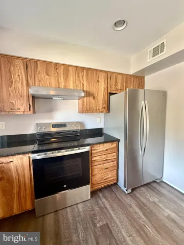 a kitchen with stainless steel appliances granite countertop a refrigerator and a stove