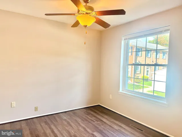 an empty room with a window and a fan