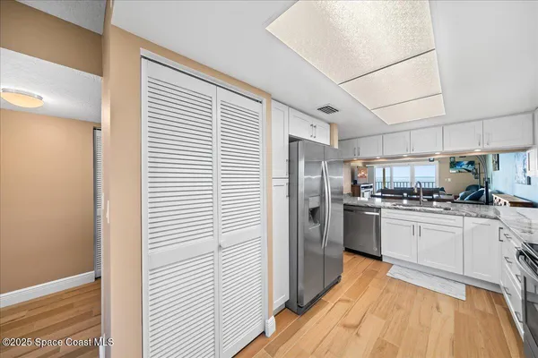 a kitchen with granite countertop a sink cabinets and stainless steel appliances