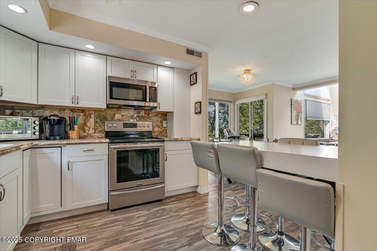 268 Big Pocono Pass Tannersville, PA 18372 - Photo 11 of 66 a kitchen with kitchen island granite countertop a stove a sink and a microwave