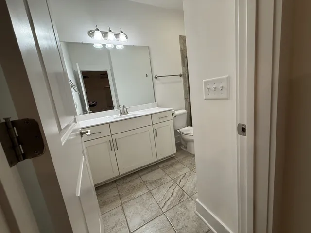 a bathroom with a sink a toilet and a mirror