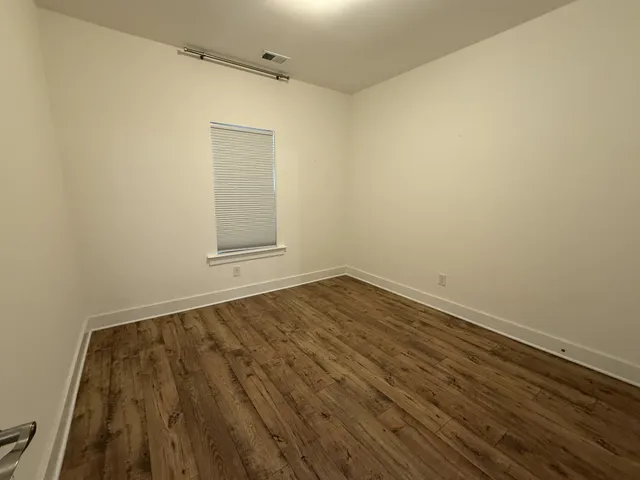 a view of a room with wooden floor and white walls