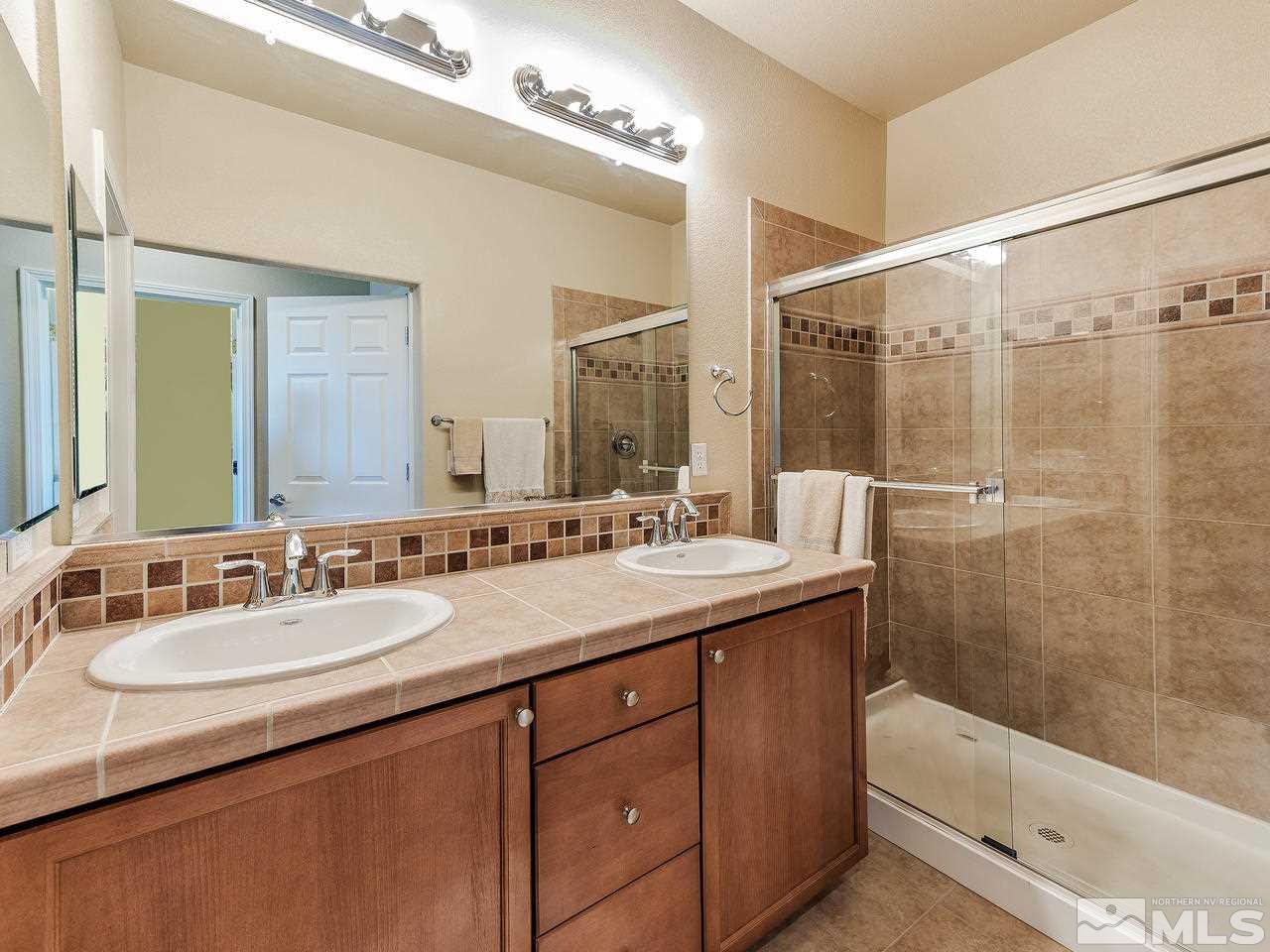 240 Gramercy Lane Reno, NV 89509 - Photo 14 of 18 a bathroom with a sink double vanity granite tub shower and a mirror