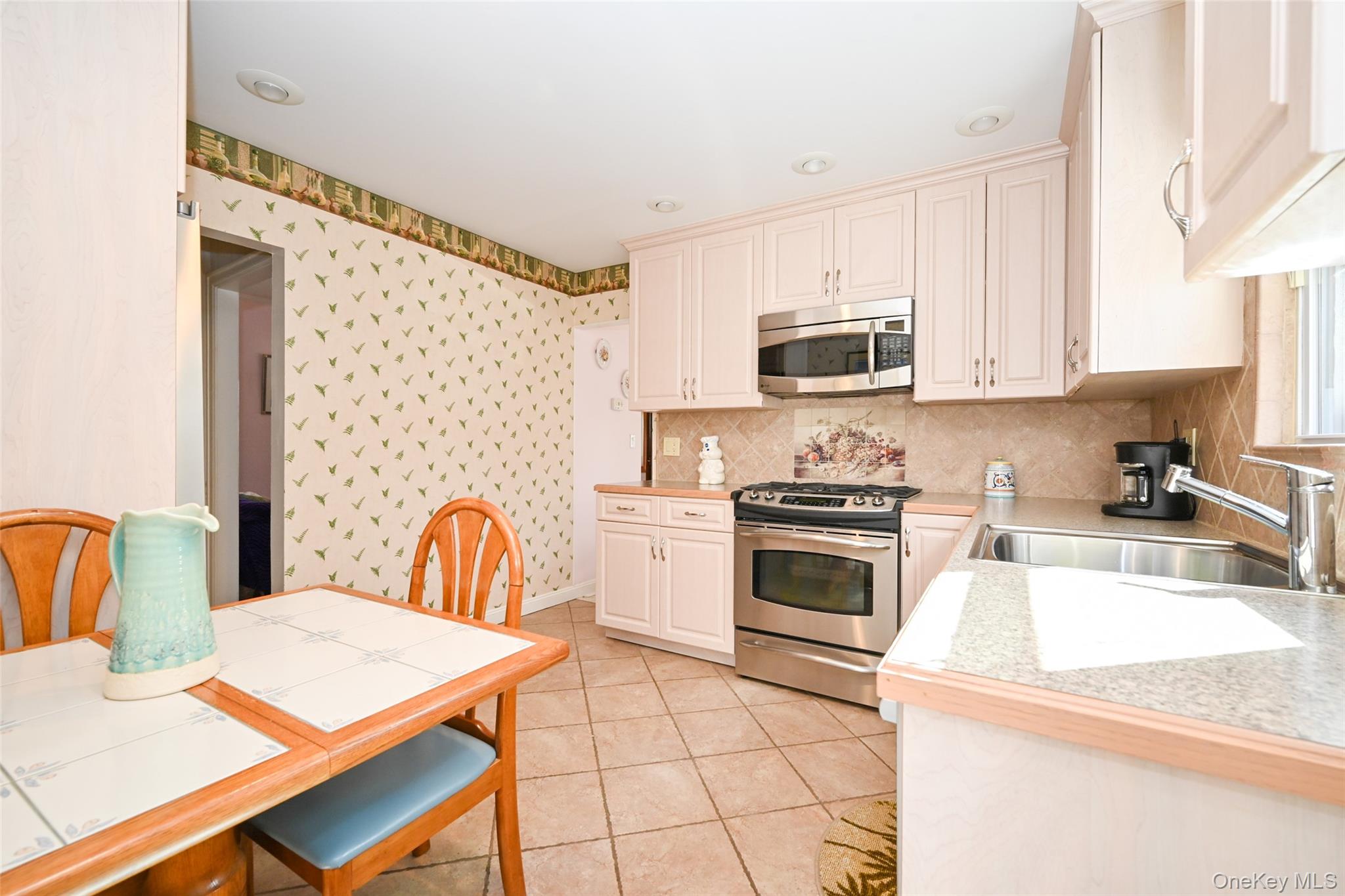 45-18 166th Street Queens, NY 11358 - Photo 5 of 20 a kitchen with granite countertop a stove a sink and a microwave
