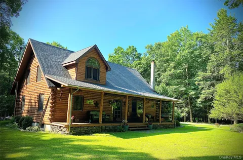 a view of a house with a yard potted plants and large tree