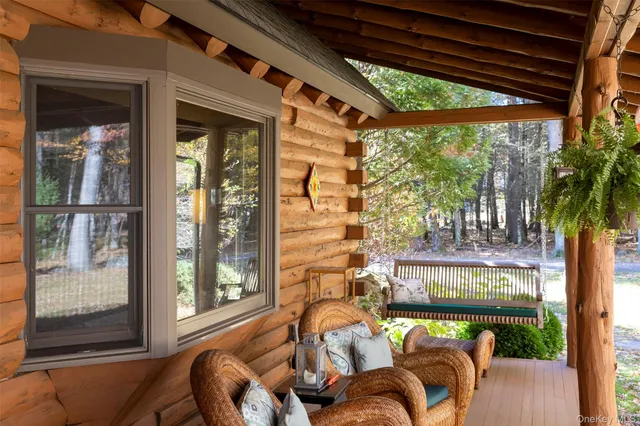 a view of a patio with couches chairs and wooden floor