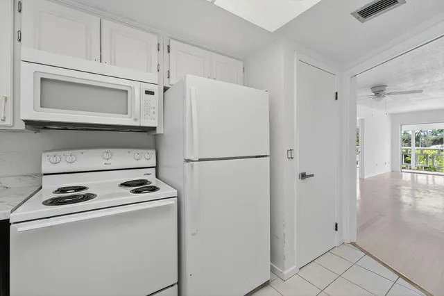 a white refrigerator freezer and a stove sitting inside of a kitchen